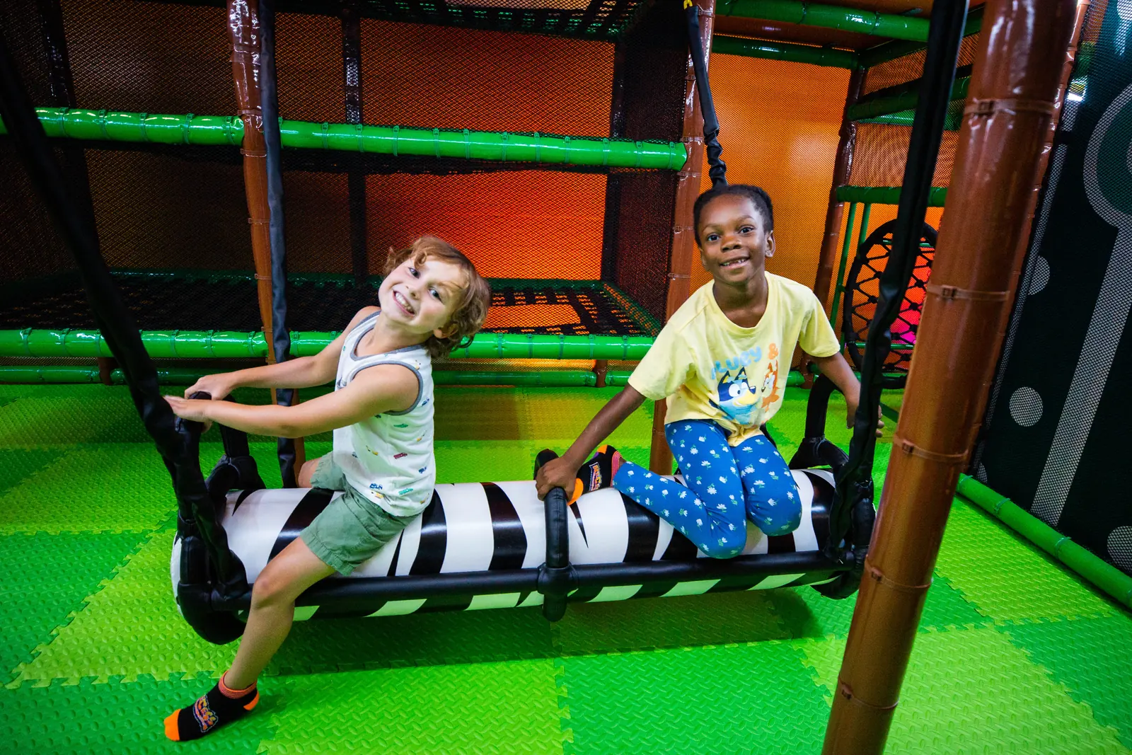 A family playing together at the indoor swings