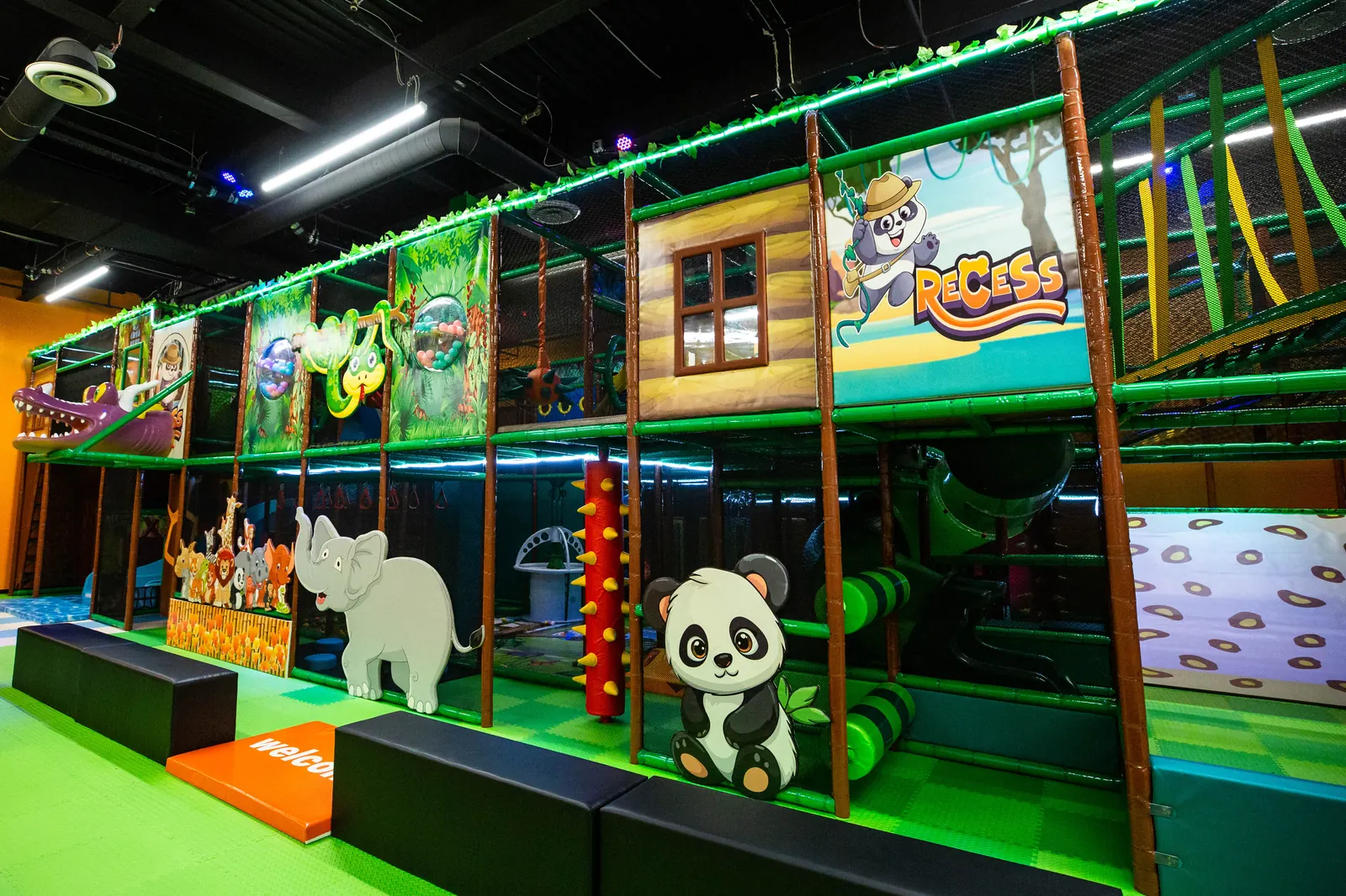 The multi-level jungle-themed play structure with animal murals and treehouse