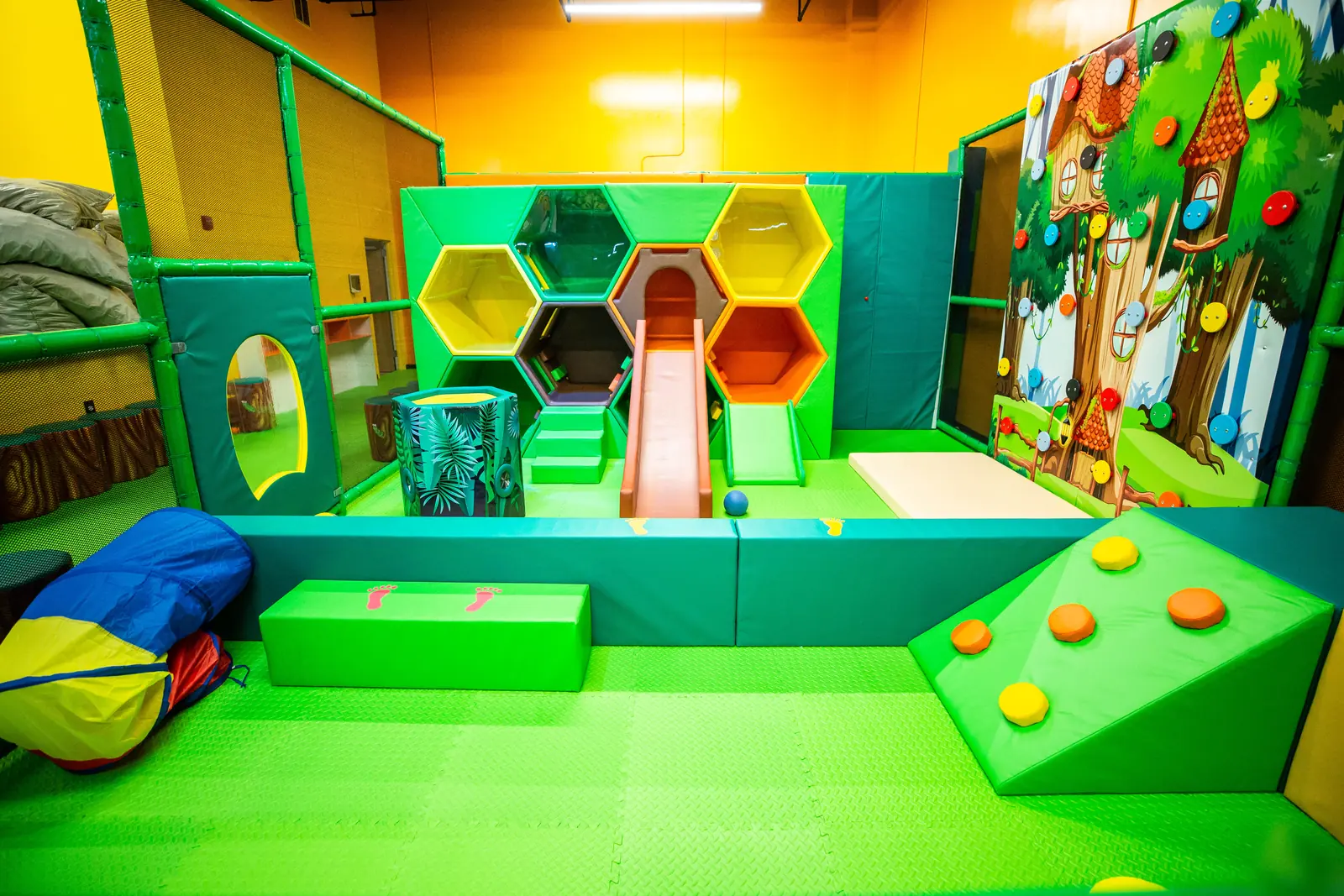 Front view of Kids Cove with its small slide, cubbies and padded play features