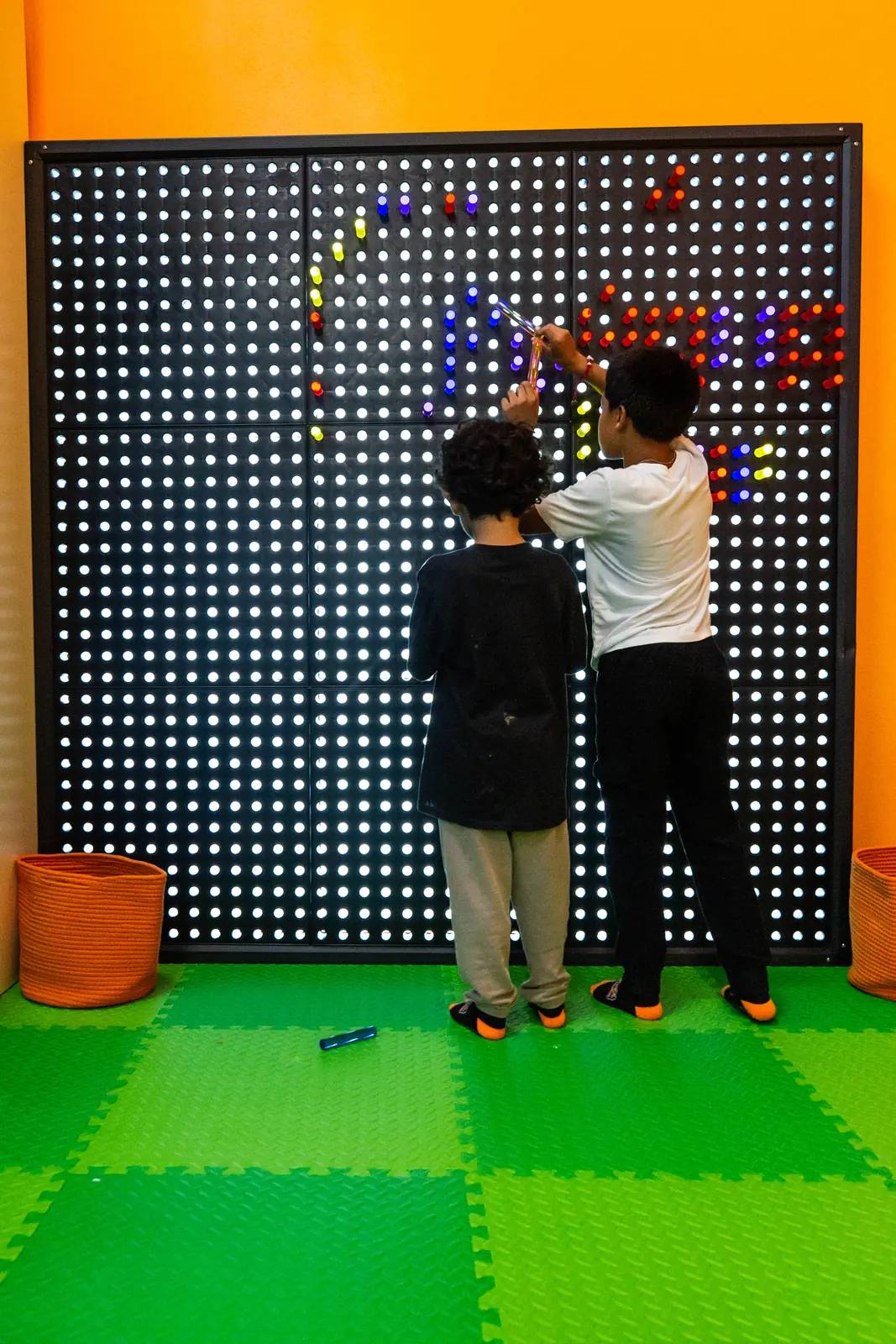 Two children playing together at the interactive light wall