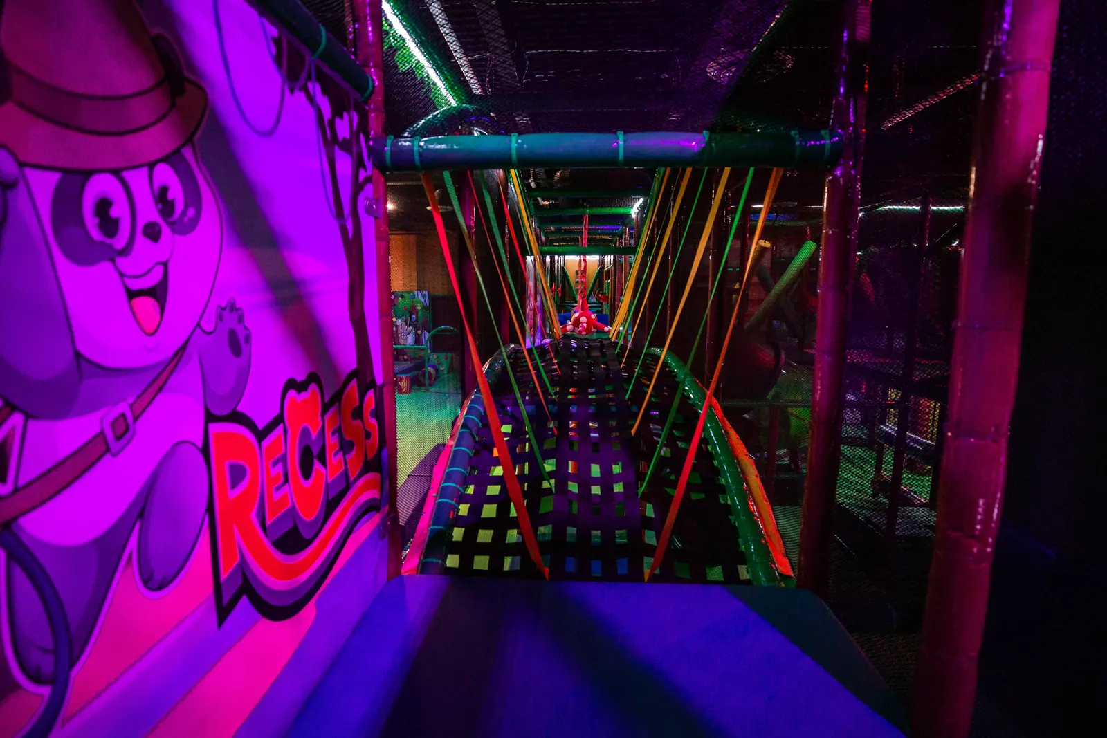 A neon-lit obstacle course section inside the play structure