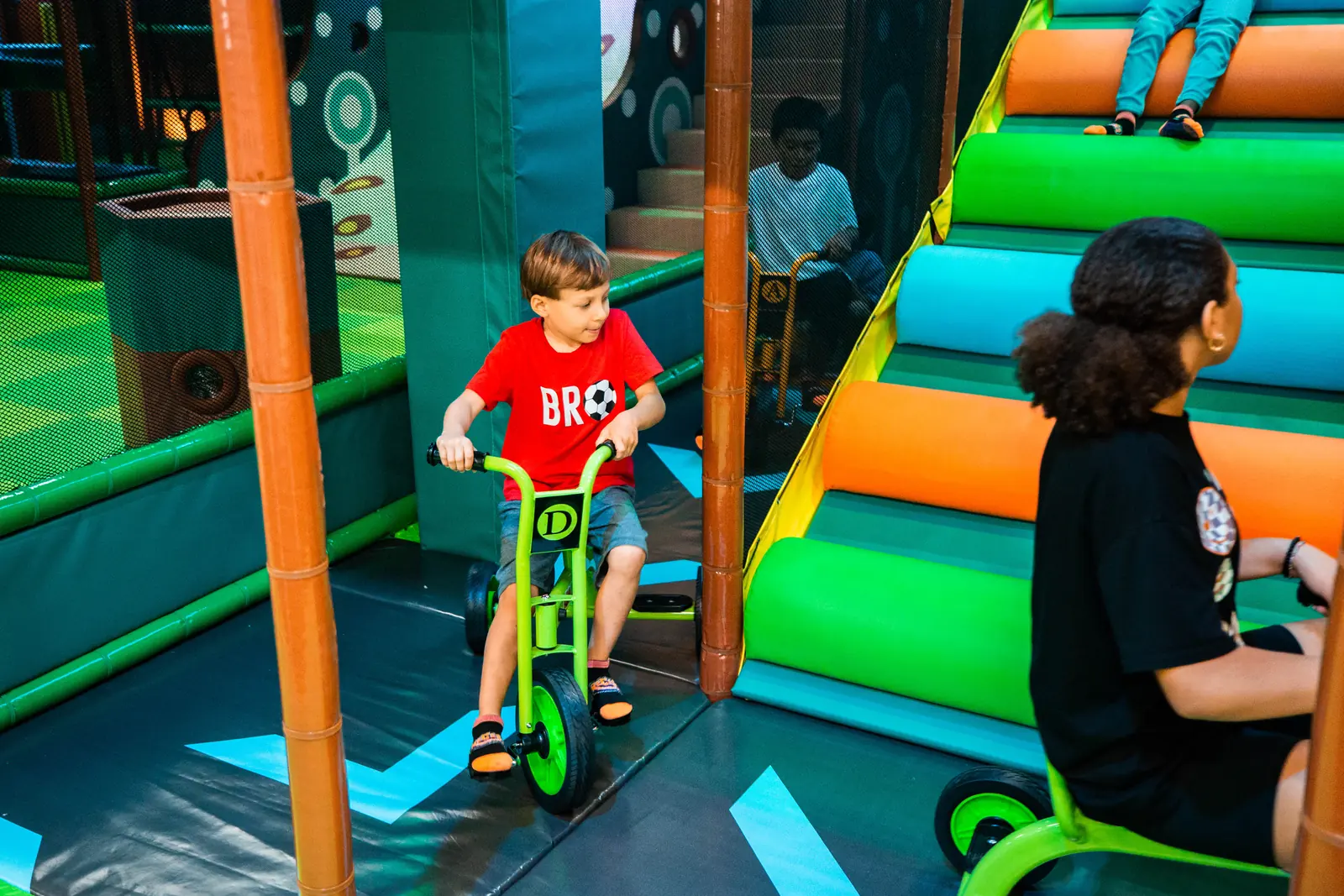A child riding a trike up the ramp on the trike course